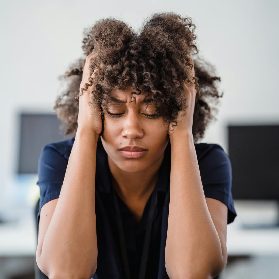 Black woman exhausted at work — why so many need a sleep aid without melatonin